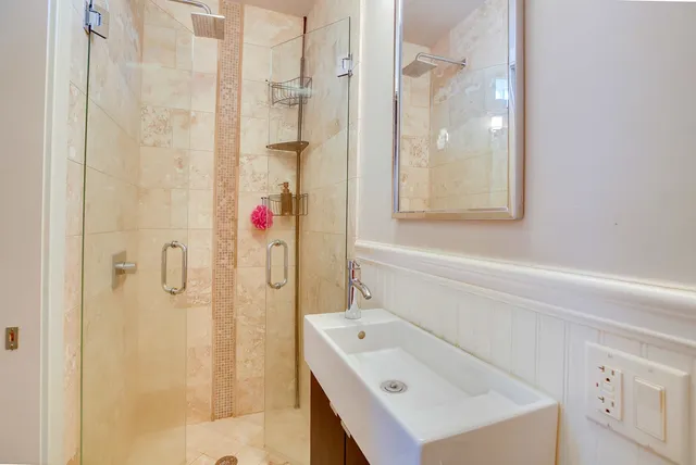 a bathroom with a sink a shower and a mirror
