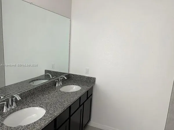 a bathroom with a granite countertop sink and a mirror