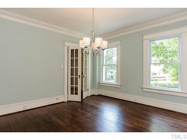 1600 St Marys Street Raleigh, NC 27608 - Photo 5 of 24 an empty room with wooden floor and chandelier