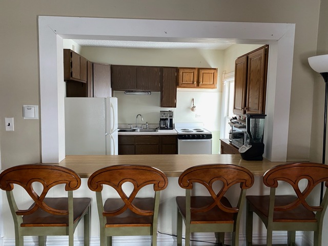 986 Main Street Antioch, IL 60002 - Photo 14 of 24 a kitchen with a table chairs stove and refrigerator