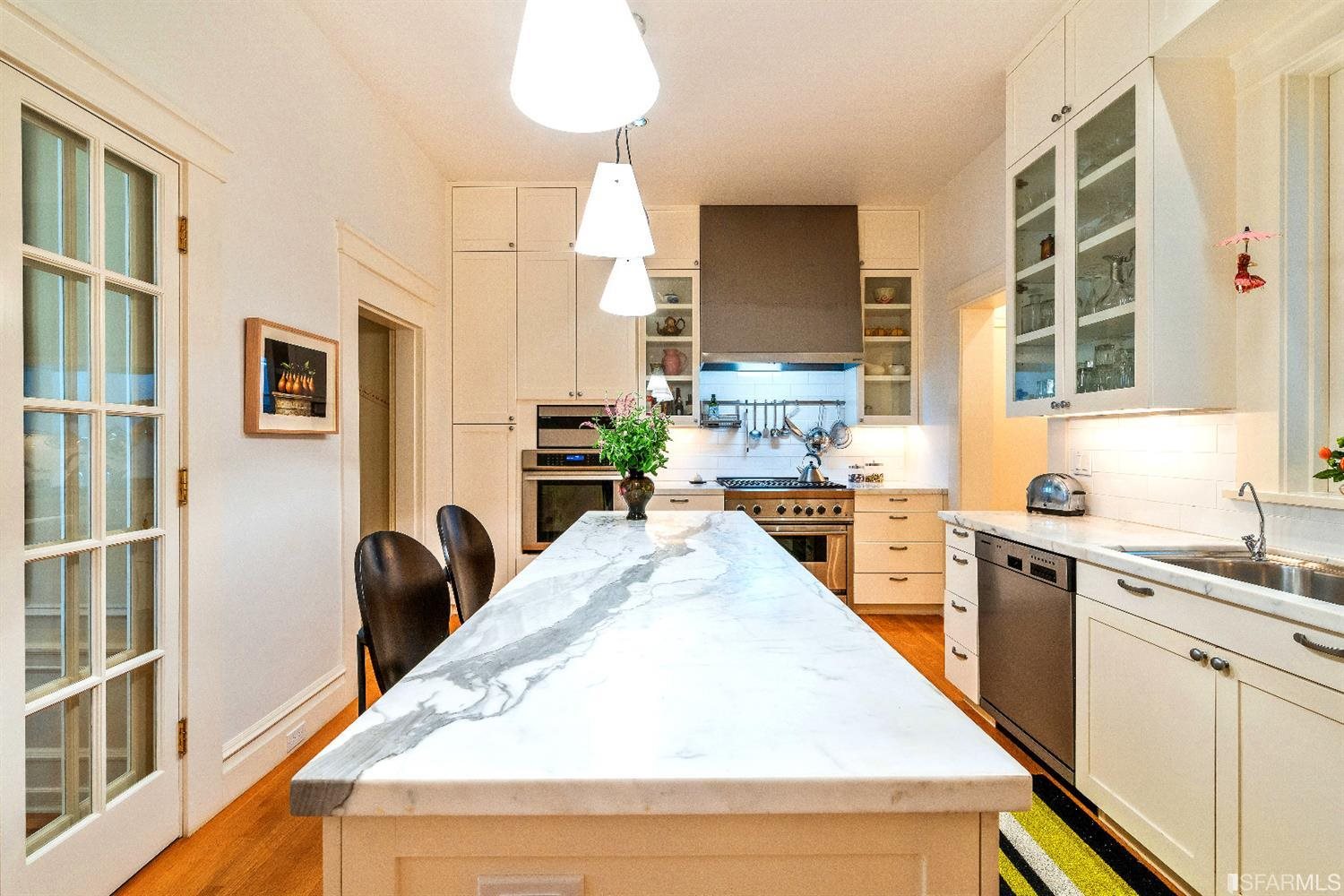 1925 Gough Street, Unit 11 San Francisco, CA 94109 - Photo 16 of 46 a kitchen with stainless steel appliances kitchen island granite countertop a sink a stove counter space and cabinets