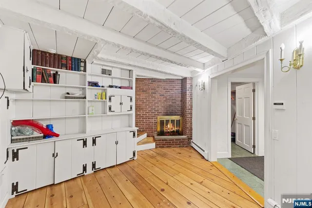 a view of a hallway with wooden floor and cabinet
