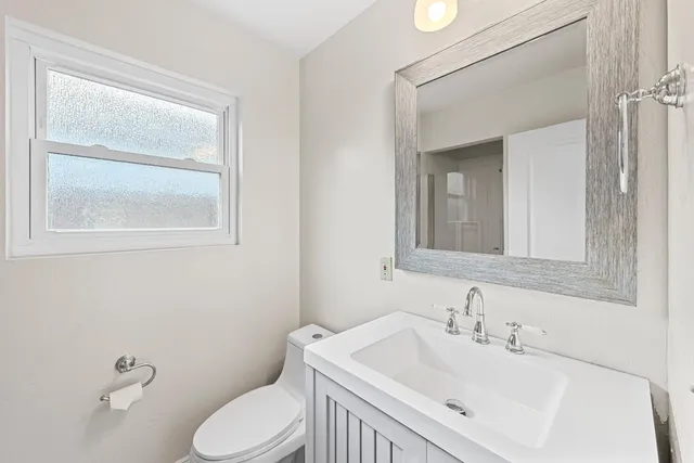 a bathroom with a sink toilet and mirror