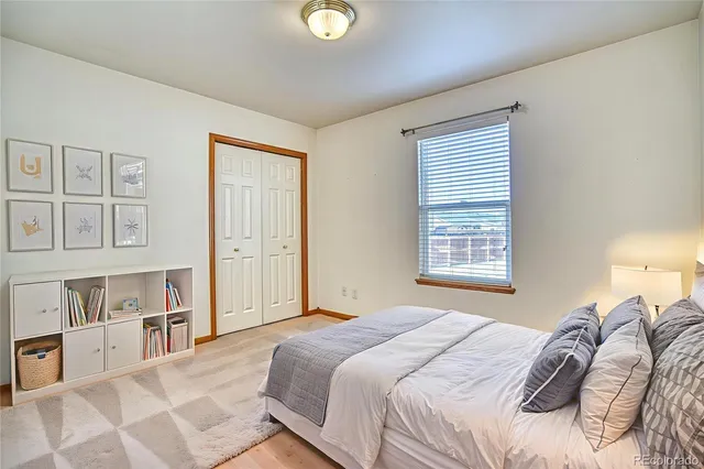 a bedroom with a bed cabinets and a window