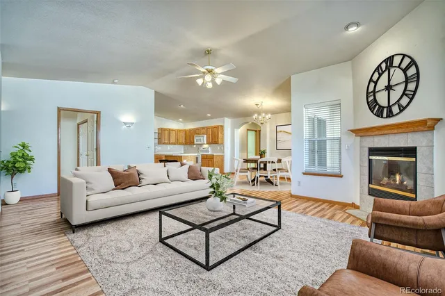 a living room with furniture a fireplace and a chandelier