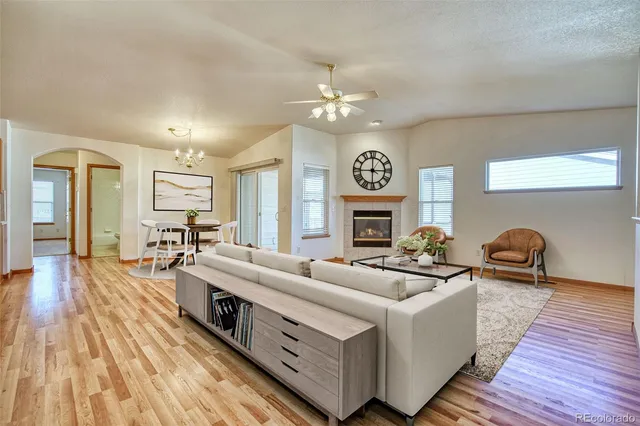 a living room with furniture a fireplace and wooden floor
