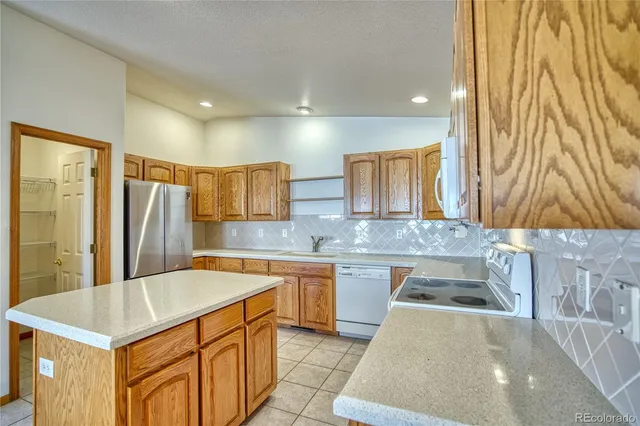 a kitchen with stainless steel appliances granite countertop a sink and a refrigerator