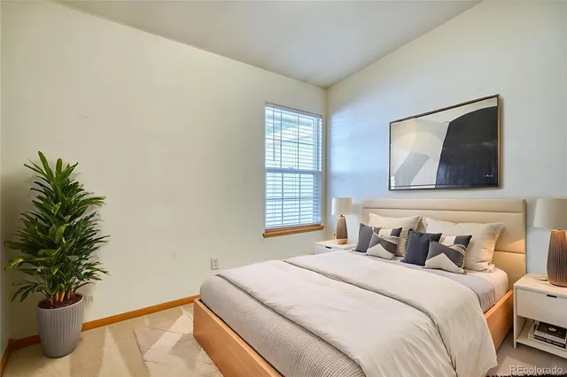 a bedroom with a bed and a potted plant