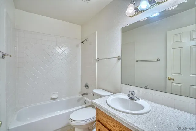 a bathroom with a granite countertop sink mirror toilet and bathtub