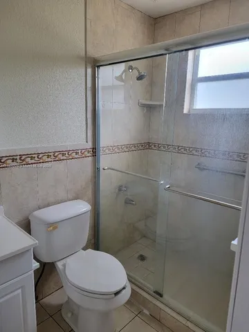 a white toilet sitting next to a shower