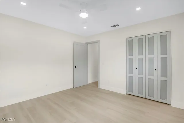 an empty room with windows & cabinet