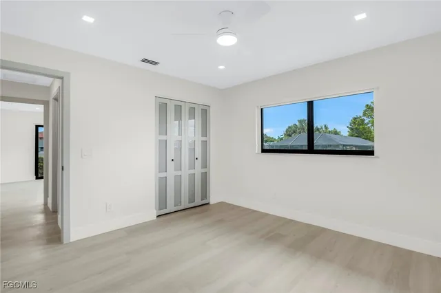 a view of a big room with wooden floor and windows