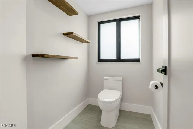 a white toilet sitting next to a bathroom sink