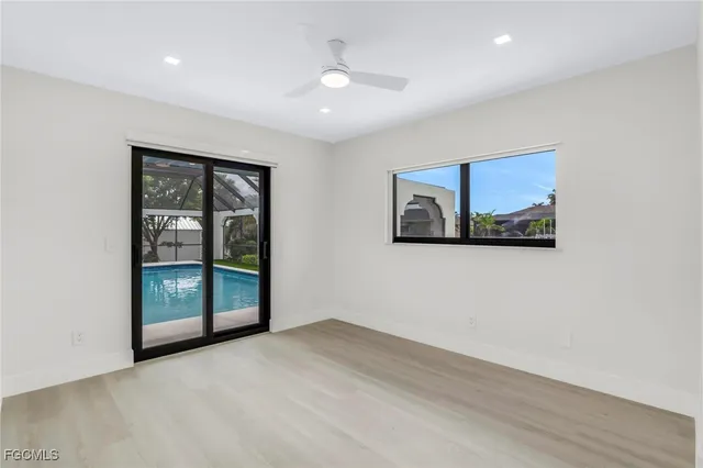 a view of an empty room with a window and a ceiling fan