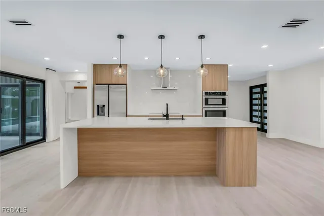 a view of kitchen with stainless steel appliances granite countertop cabinets and wooden floor