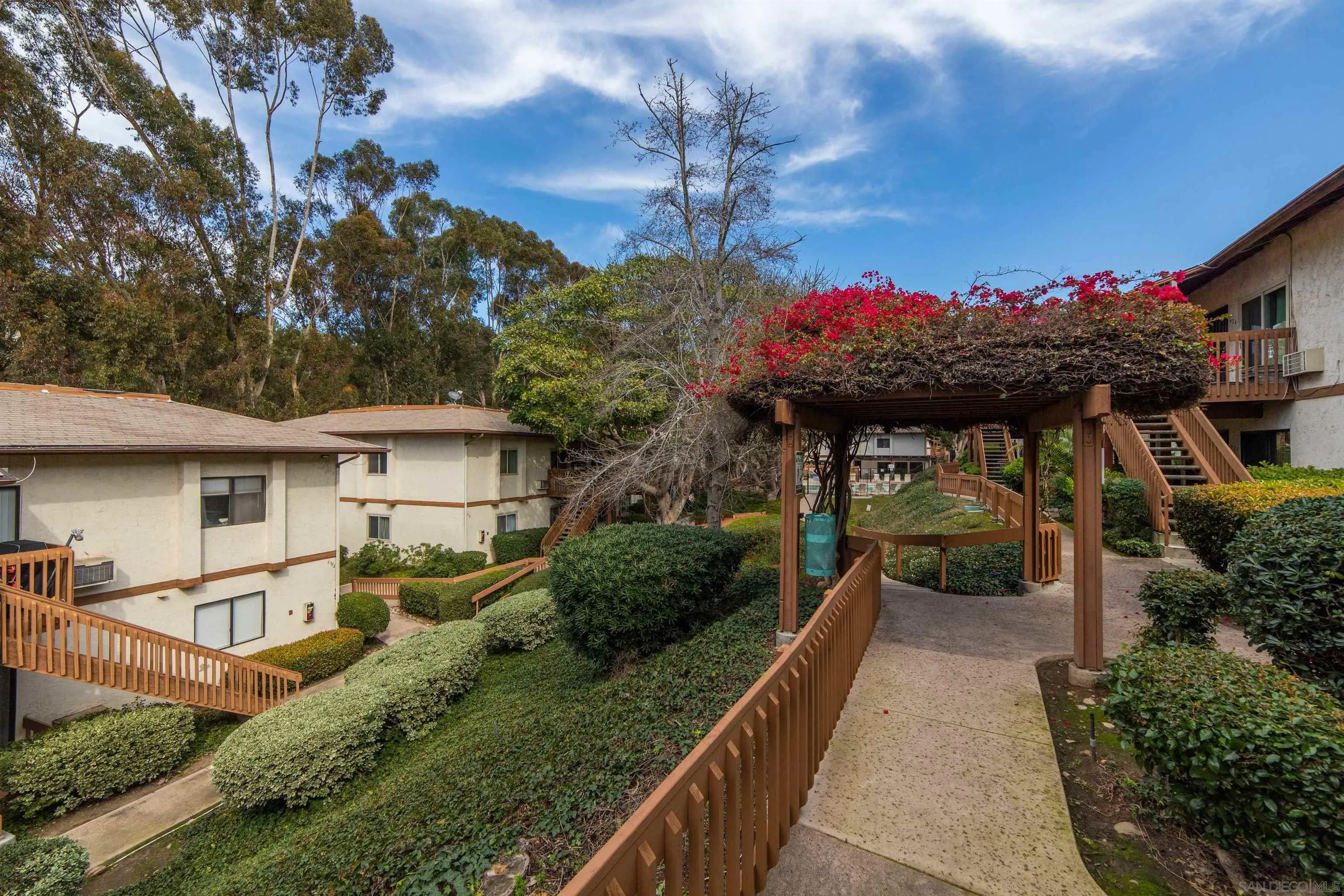 6370 Rancho Mission Road, Unit 913 San Diego, CA 92108 - Photo 18 of 30 a view of a house with a small yard and a large tree