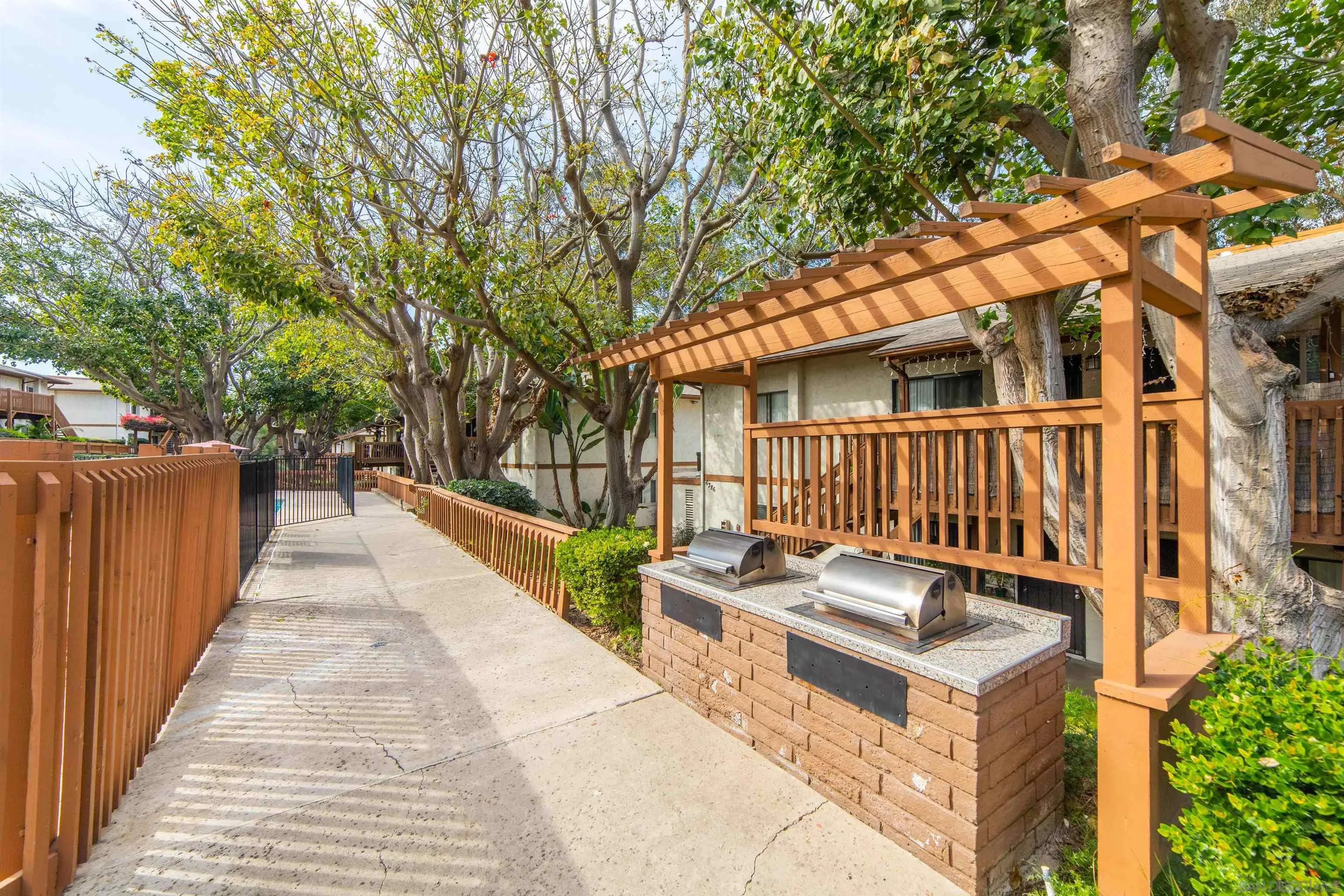 6370 Rancho Mission Road, Unit 913 San Diego, CA 92108 - Photo 23 of 30 a view of a backyard with couches and wooden fence