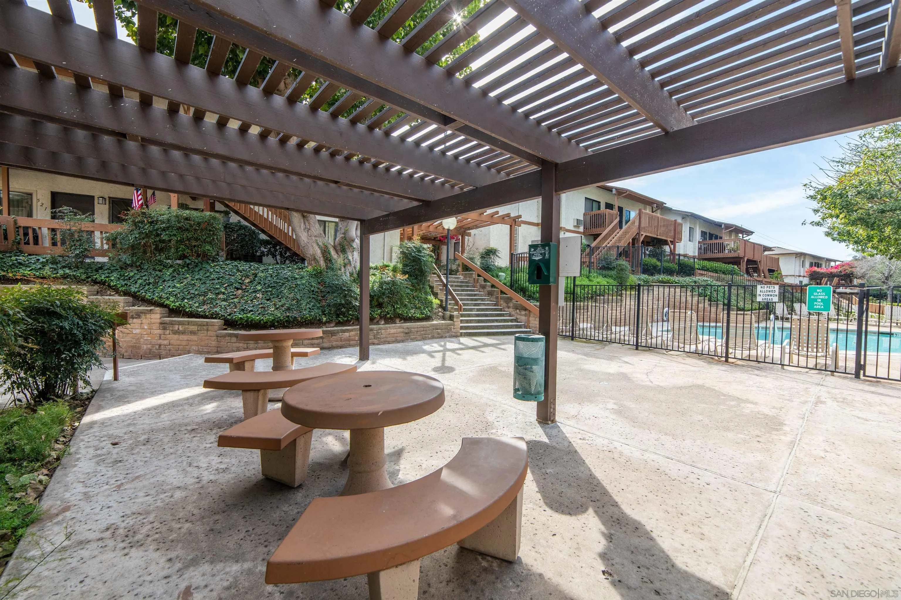 6370 Rancho Mission Road, Unit 913 San Diego, CA 92108 - Photo 28 of 30 a view of a patio with a table and chairs next to a yard