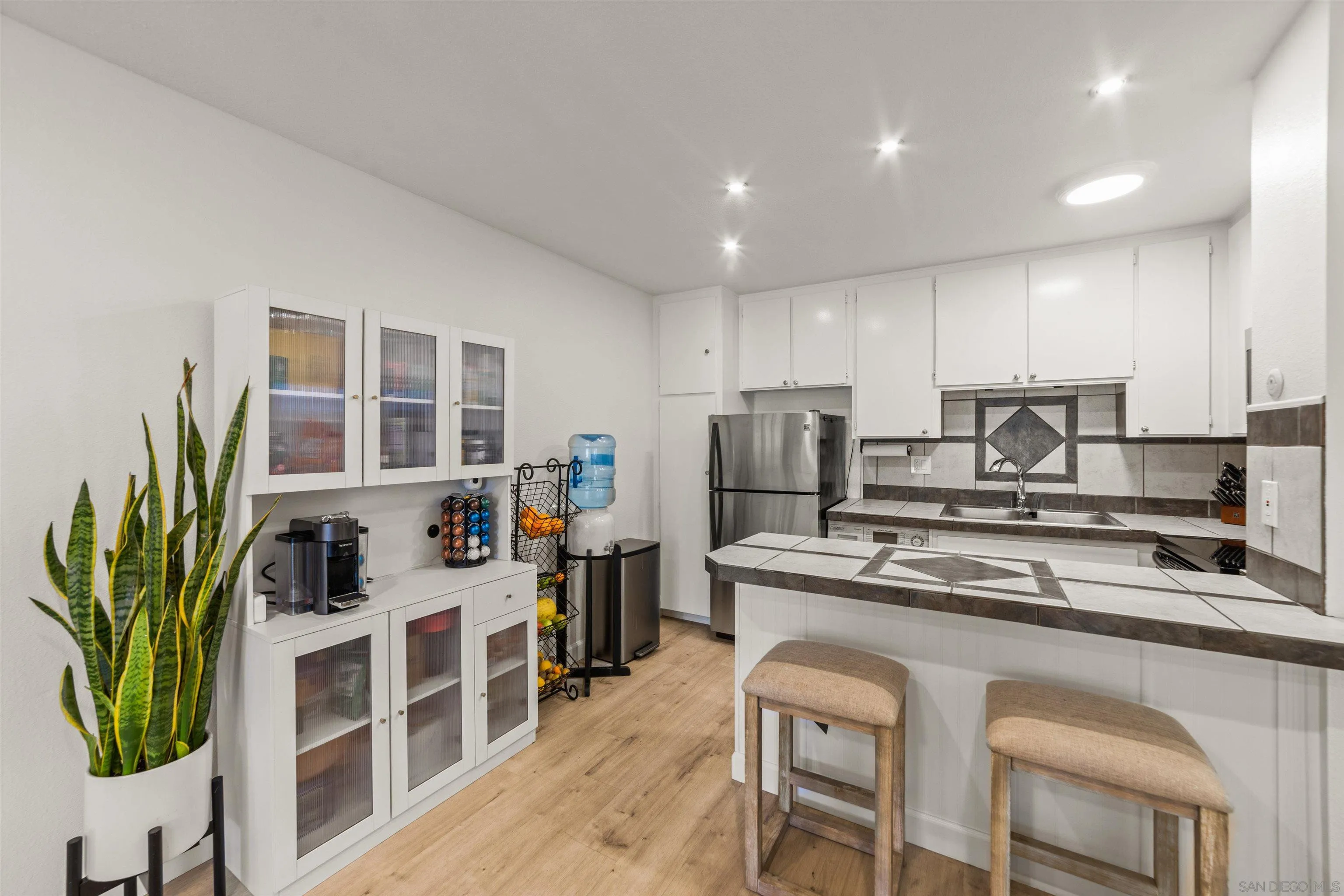 6370 Rancho Mission Road, Unit 913 San Diego, CA 92108 - Photo 6 of 30 a kitchen that has a lot of cabinets in it with stainless steel appliances granite countertop a stove a sink a refrigerator a counter space and cabinets