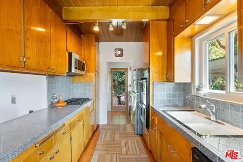 a kitchen with a sink a counter top space and stainless steel appliances