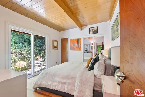 a bed room with a bed and a painting on the wall