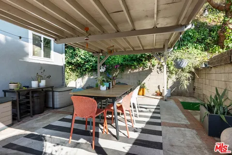a view of a patio with table and chairs potted plants with wooden floor