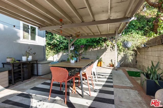 a view of a patio with table and chairs potted plants with wooden floor