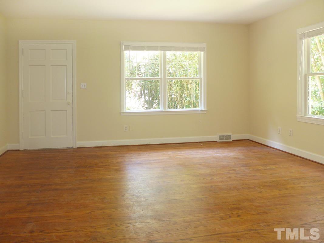 731 Raleigh Road Chapel Hill, NC 27514 - Photo 4 of 14 an empty room with wooden floor and windows