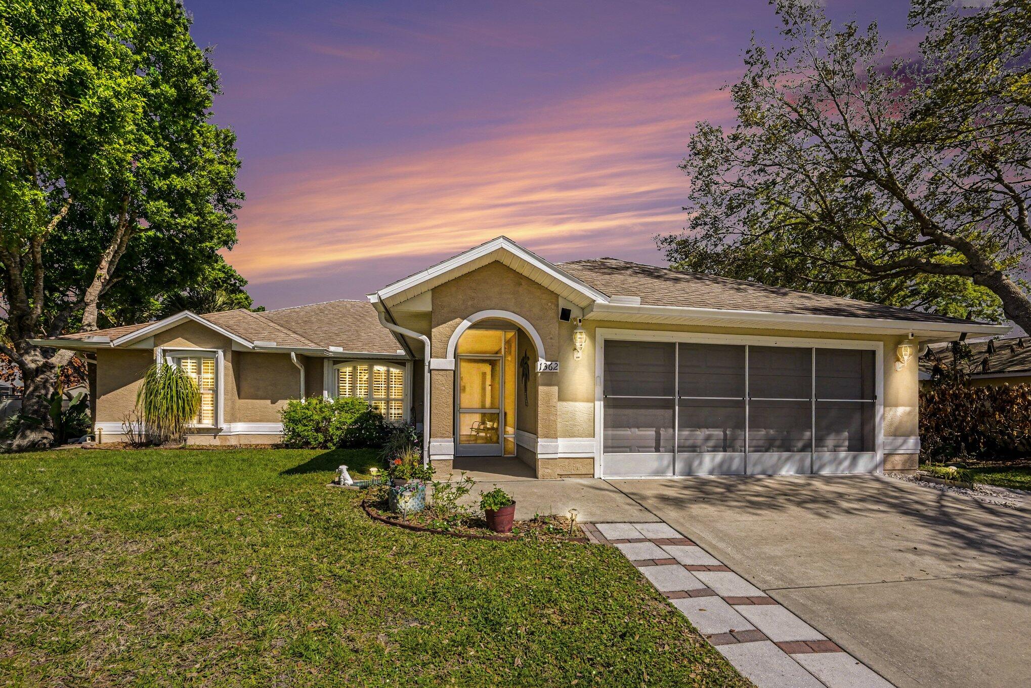 1362 Seahouse Street Sebastian, FL 32958 - Photo 1 of 28 a front view of a house with a yard and potted plants