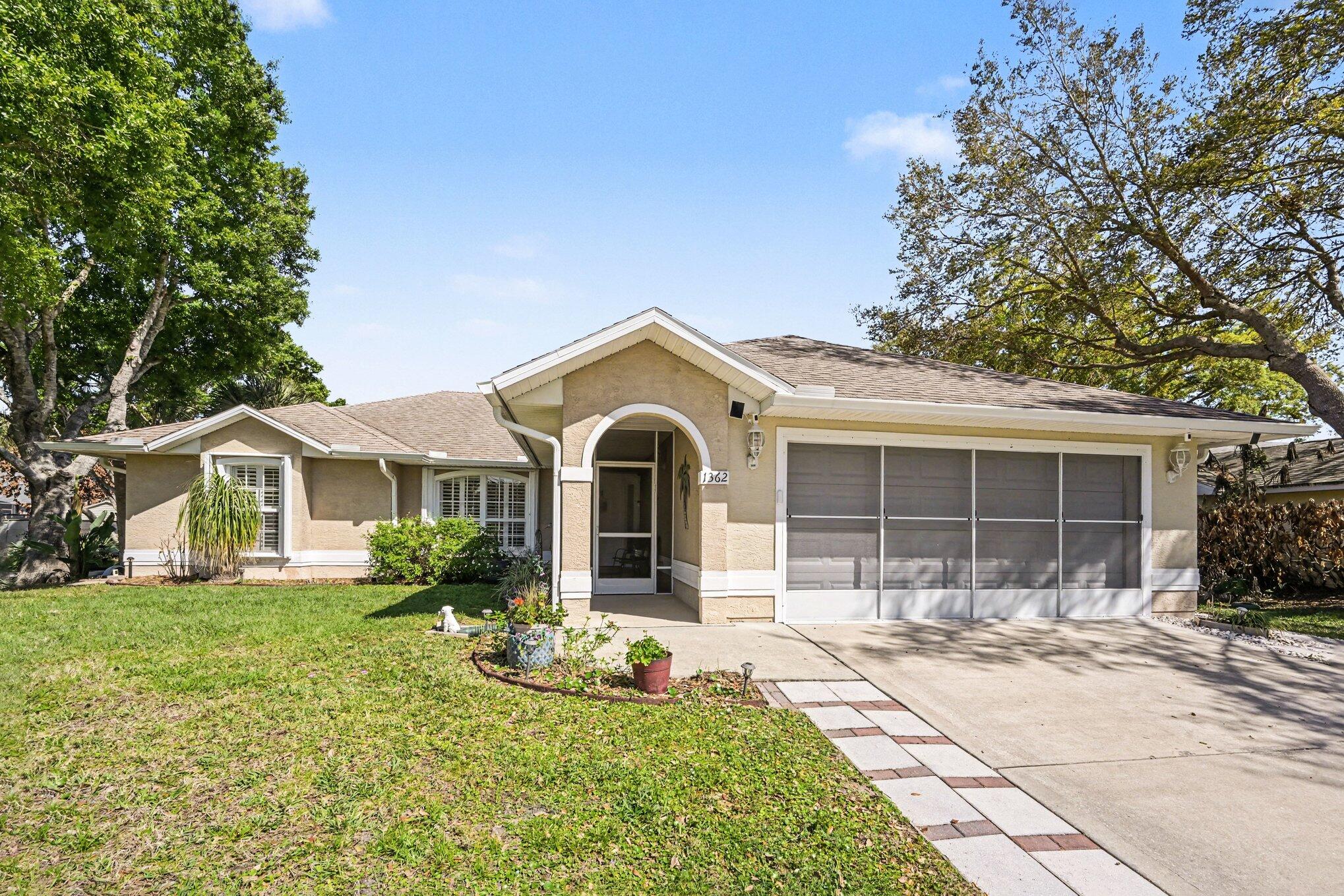 1362 Seahouse Street Sebastian, FL 32958 - Photo 2 of 28 a front view of a house with garden