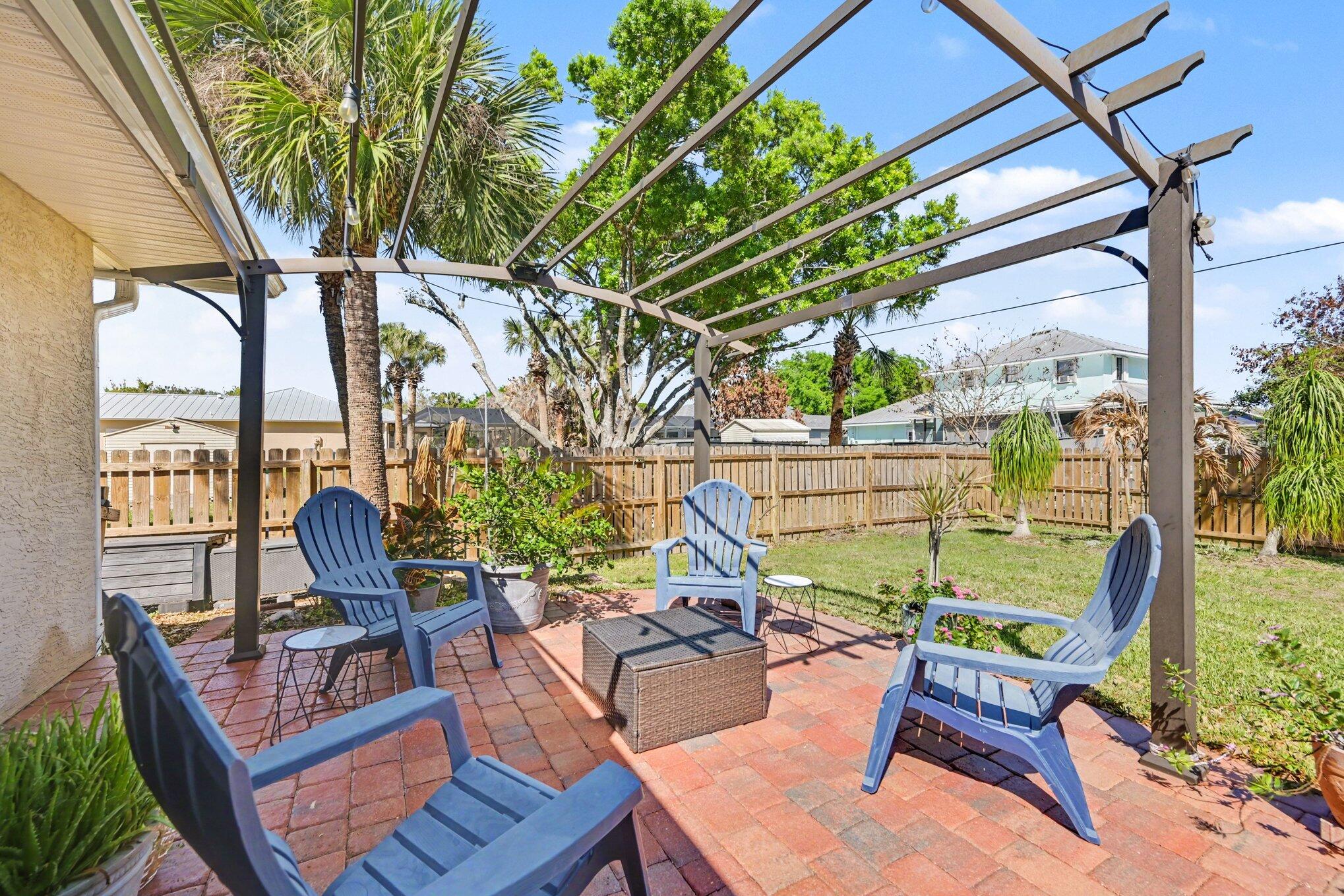 1362 Seahouse Street Sebastian, FL 32958 - Photo 25 of 28 a view of a patio with couches chairs and a potted plant