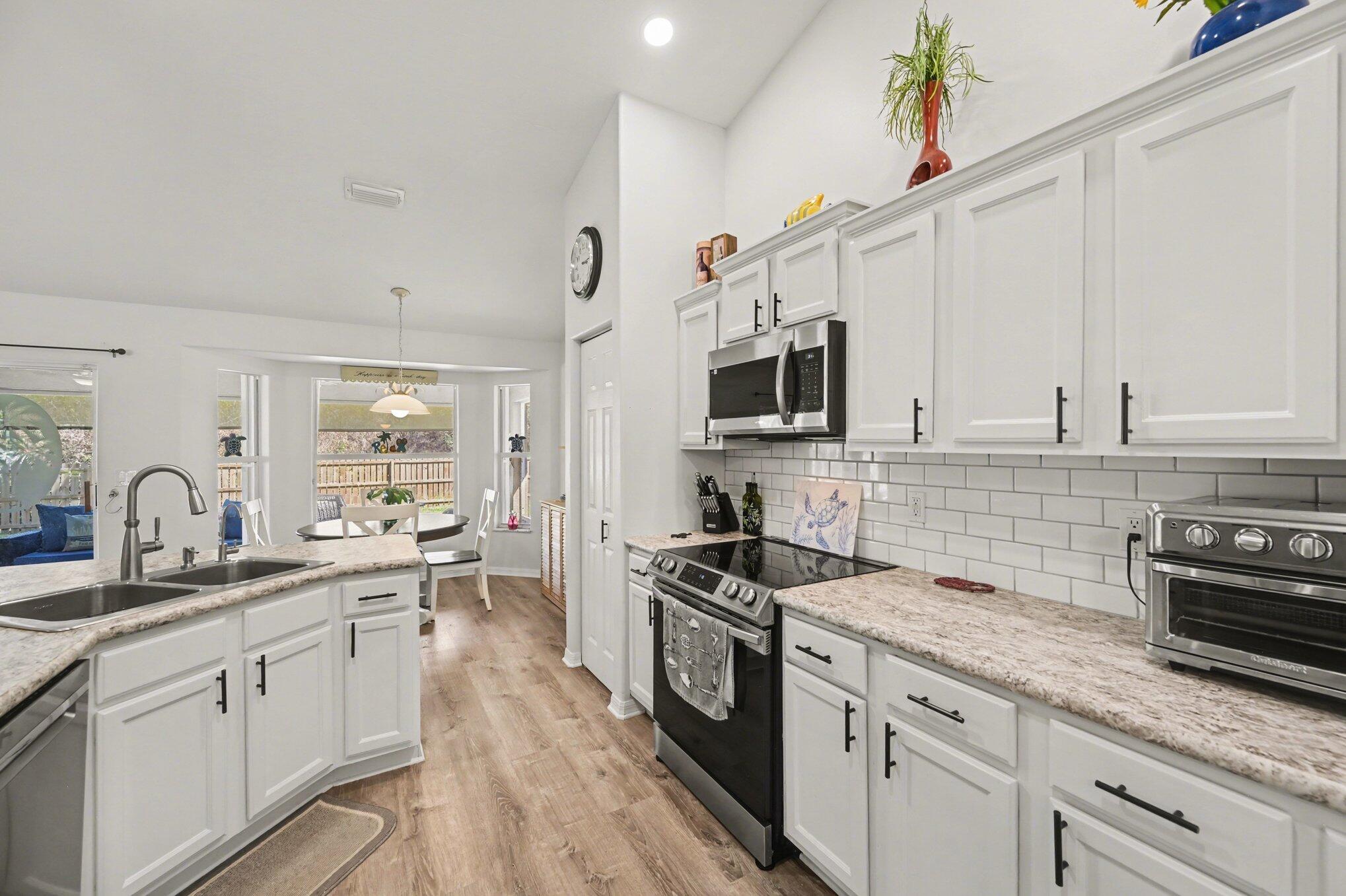 1362 Seahouse Street Sebastian, FL 32958 - Photo 7 of 28 a kitchen with granite countertop a sink stainless steel appliances and cabinets