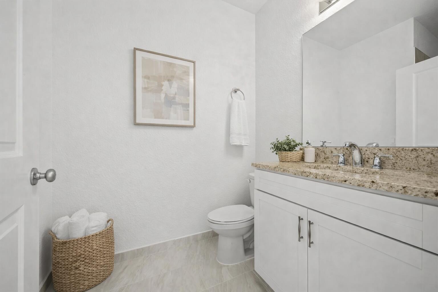 2575 Southeast Bonita Street Stuart, FL 34997 - Photo 4 of 17 a bathroom with a granite countertop sink a toilet and mirror