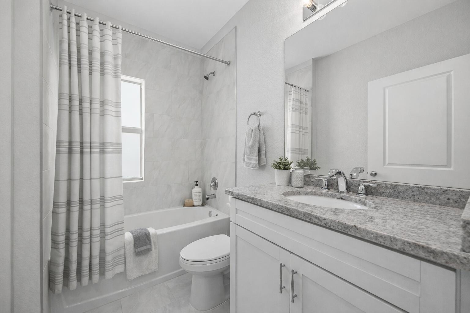 2575 Southeast Bonita Street Stuart, FL 34997 - Photo 5 of 17 a bathroom with a granite countertop sink a toilet and a large mirror