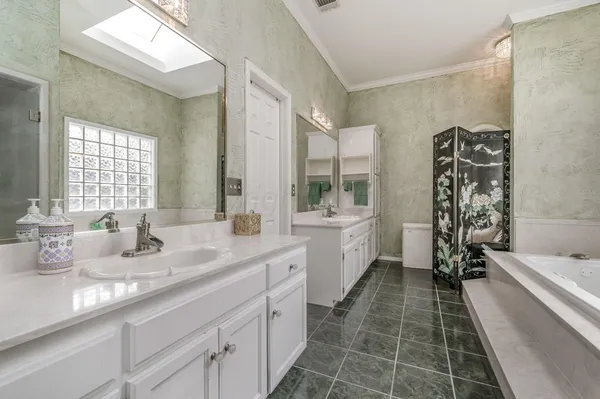 a bathroom with a double vanity sink a mirror and a bathtub