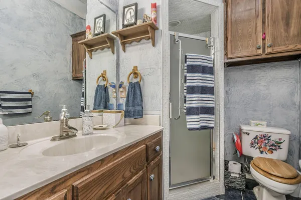 a bathroom with a granite countertop sink toilet and shower