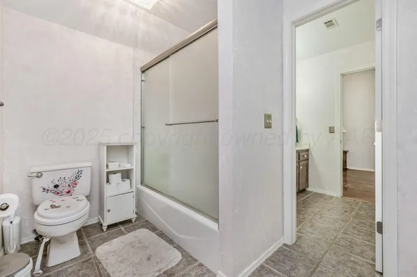 a view of a hallway with bathroom and wooden floor