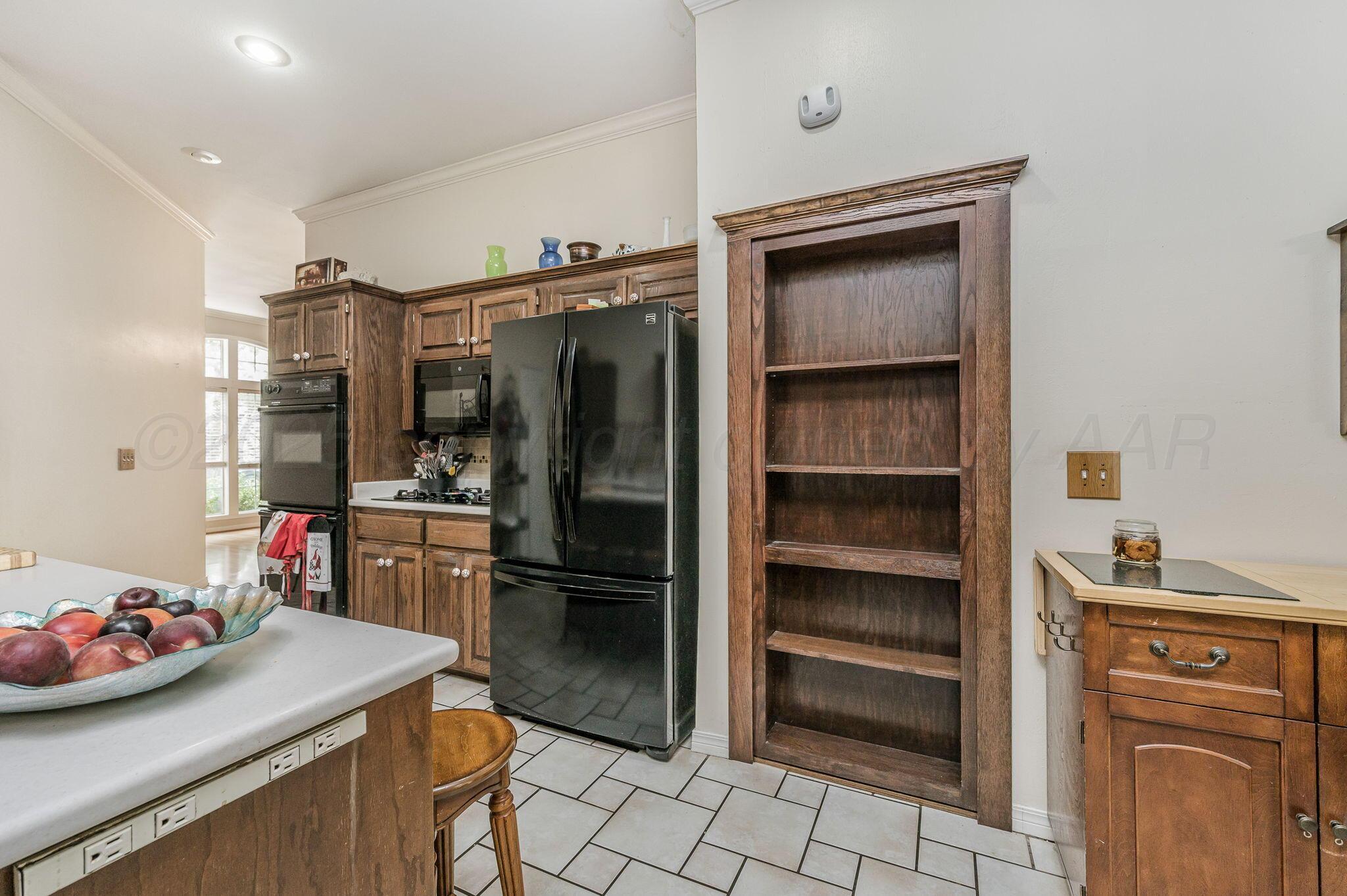 7809 Bent Tree Drive Amarillo, TX 79121 - Photo 10 of 32 a kitchen with a refrigerator and a stove top oven
