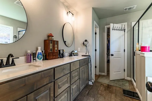 a en suite bathroom with a double vanity sink and a mirror