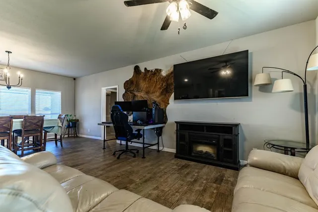 a living room with furniture a flat screen tv and a fireplace