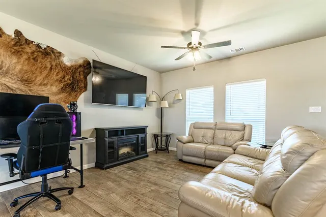 a living room with furniture a flat screen tv and a fireplace
