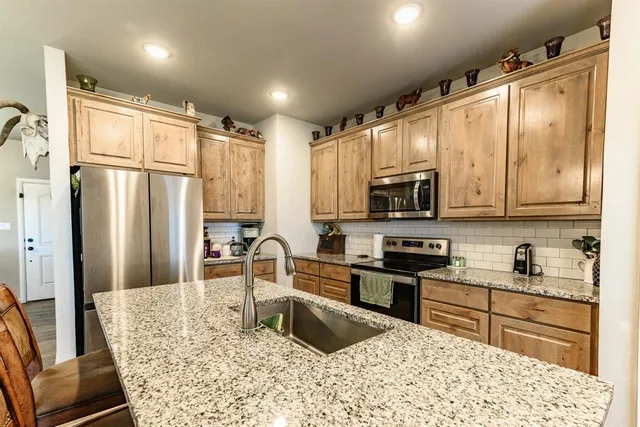 a kitchen with stainless steel appliances granite countertop a refrigerator stove and sink