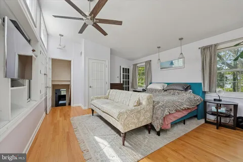 a spacious bedroom with a large bed a chandelier and windows