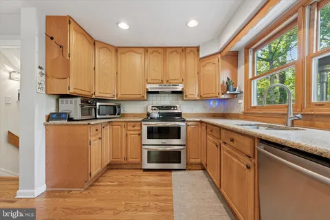 a kitchen with stainless steel appliances granite countertop a stove a sink and a microwave
