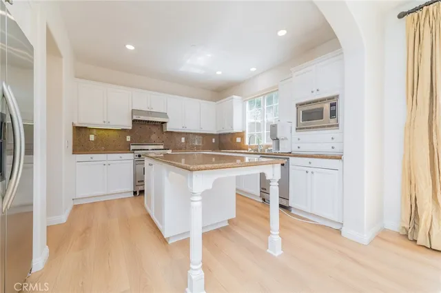 a kitchen with white cabinets and white appliances