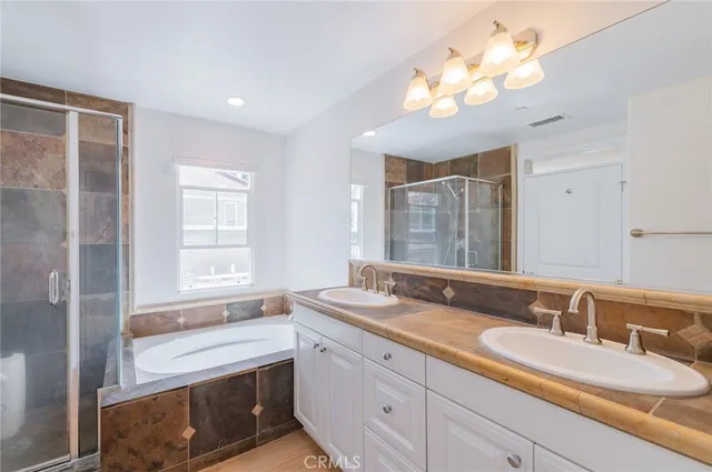 a bathroom with double vanity sinks and a mirror