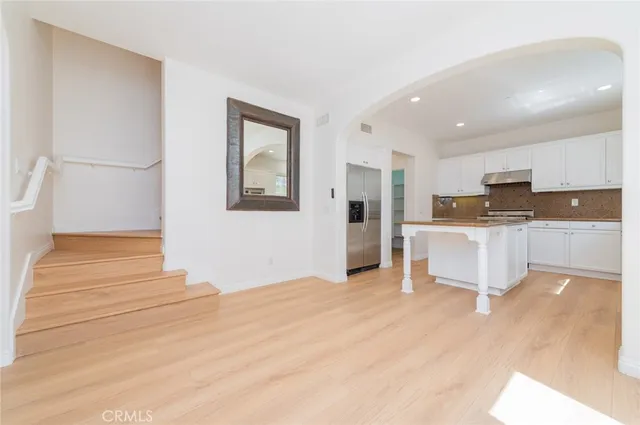 a large white kitchen with kitchen island a sink a stove a refrigerator and white cabinets