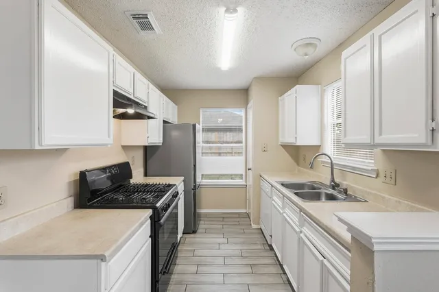 a kitchen with a sink dishwasher a stove and a refrigerator