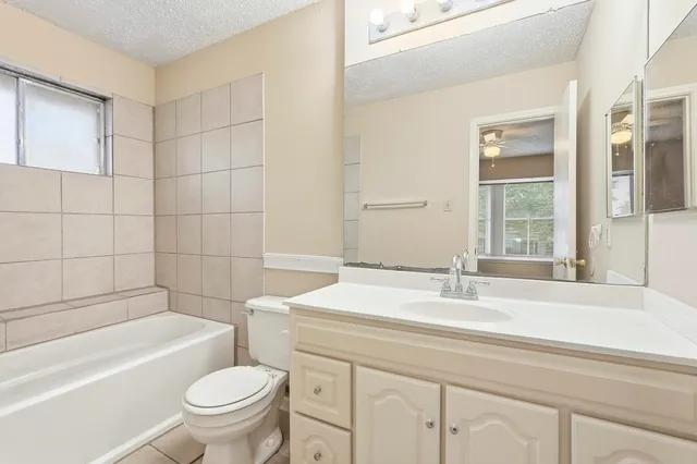 a bathroom with a sink toilet vanity and bathtub