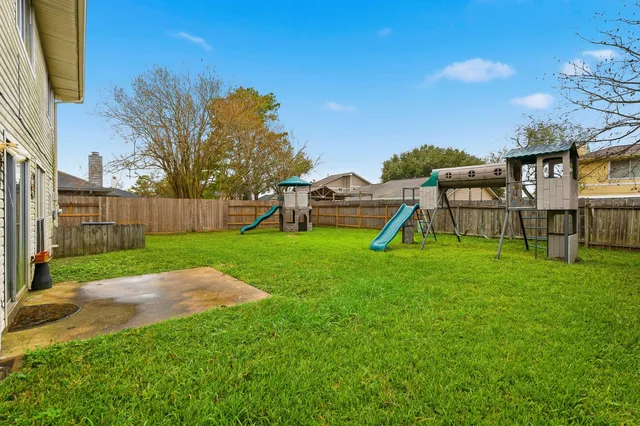 a view of a backyard with table and chairs a barbeque and wooden fence